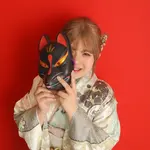赤い背景で狐面を手にした振袖姿の成人前撮りポートレート