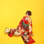 黄色い背景で赤い振袖姿を撮影したレトロな成人前撮り