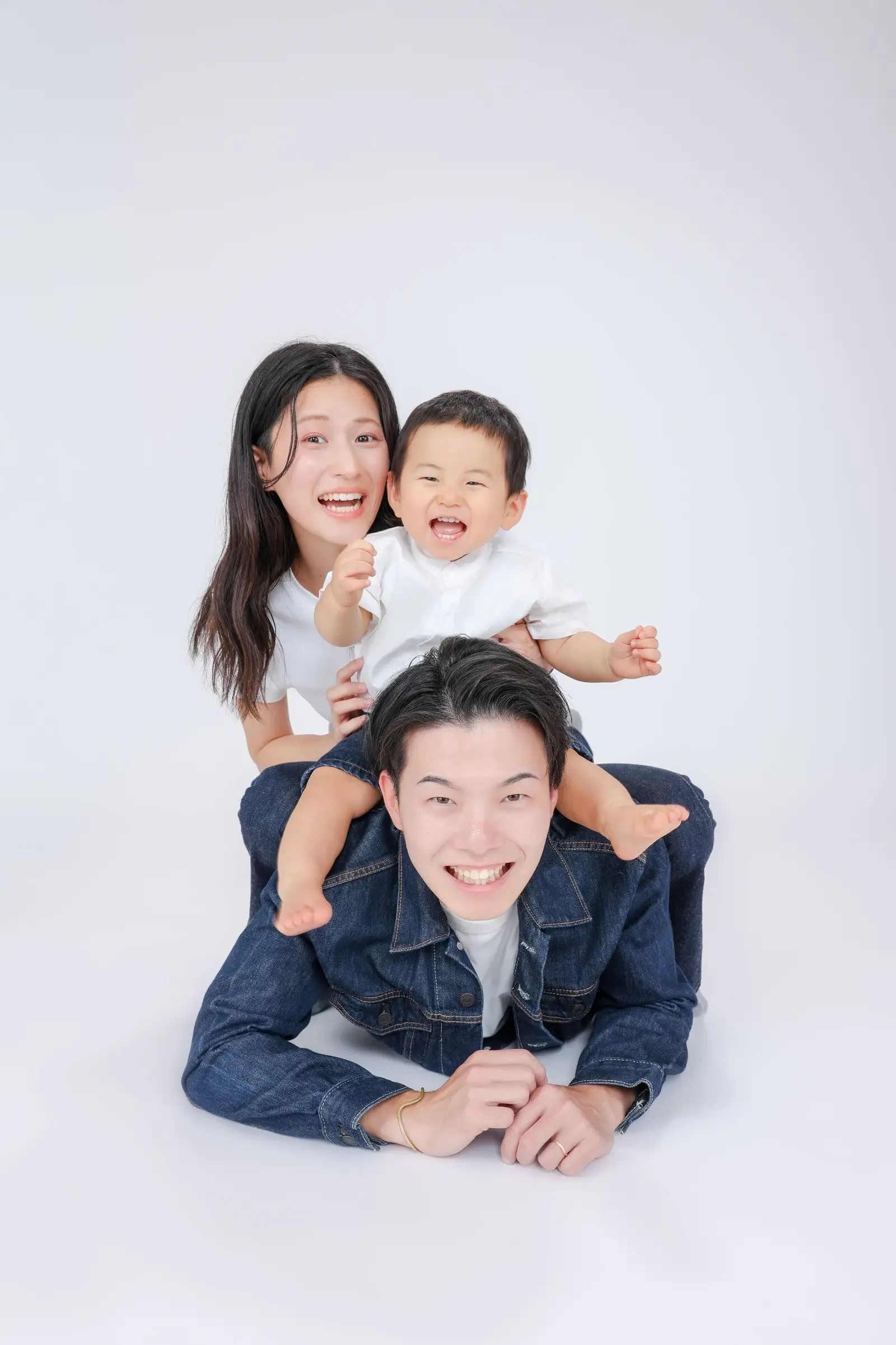 父親の背中に子どもと母親が重なって笑う家族