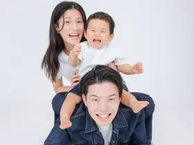 父親の背中に子どもと母親が重なって笑う家族