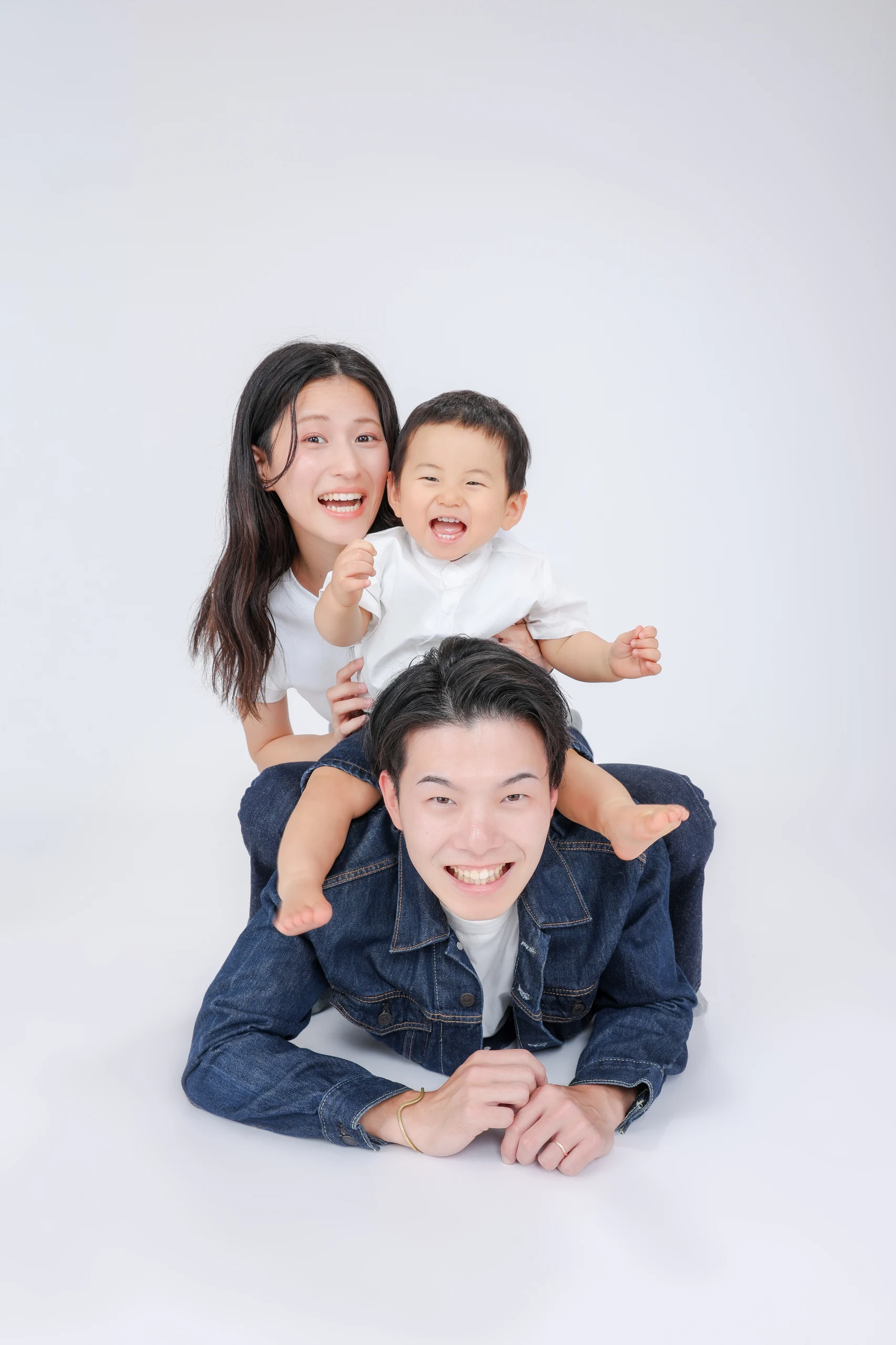 父親の背中に子どもと母親が重なって笑う家族