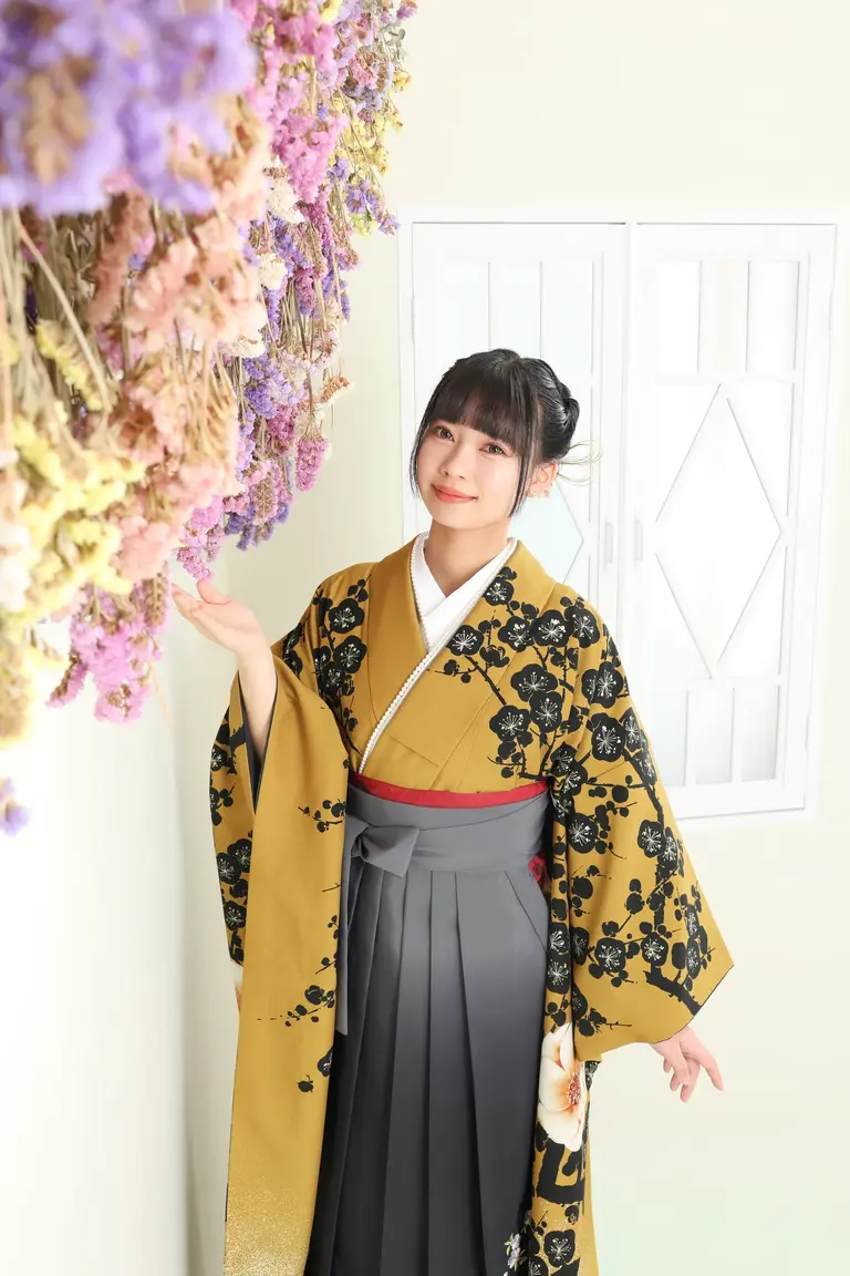 花と一緒に卒業袴で撮る女性
