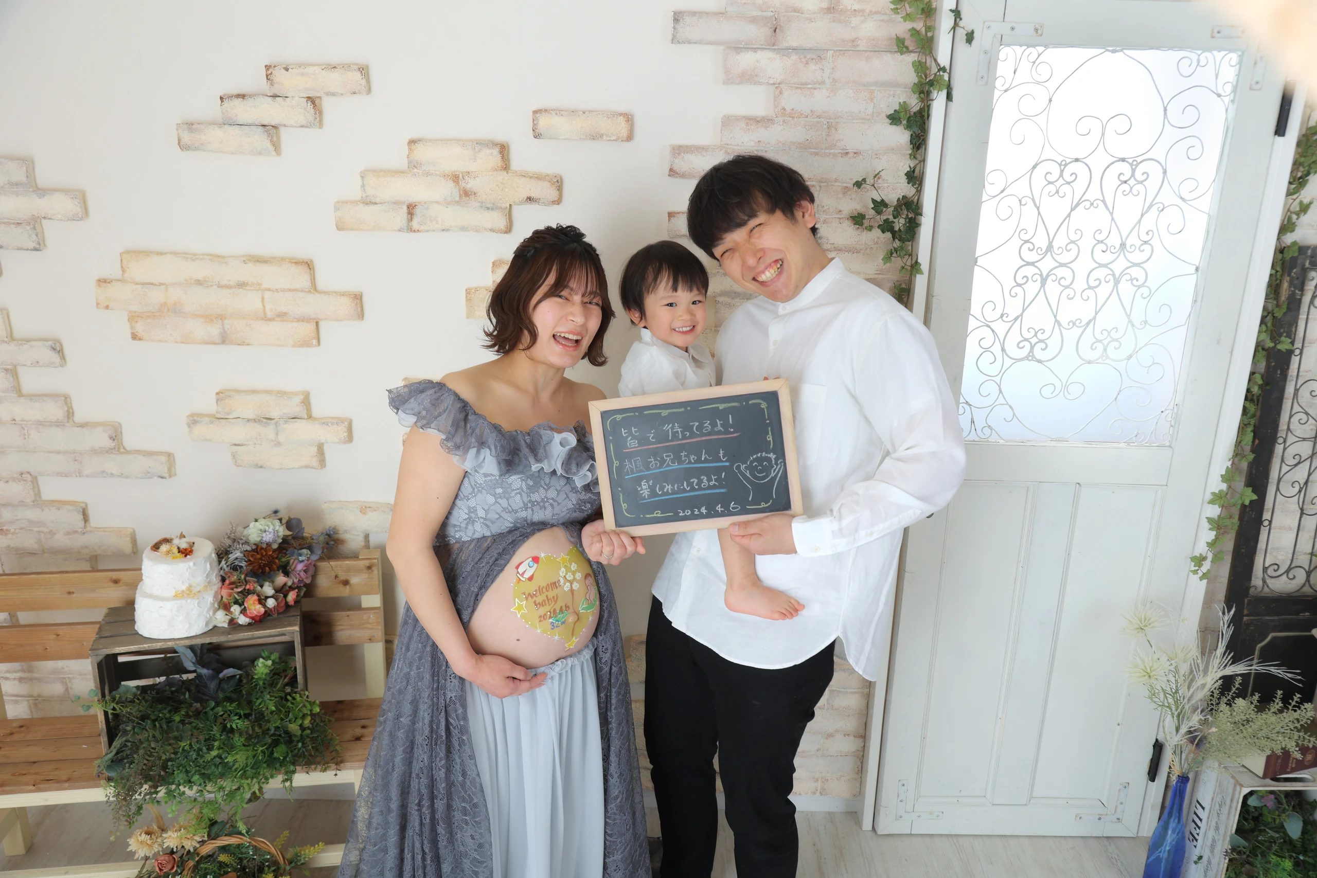Family smiling around a pregnant woman with belly paint