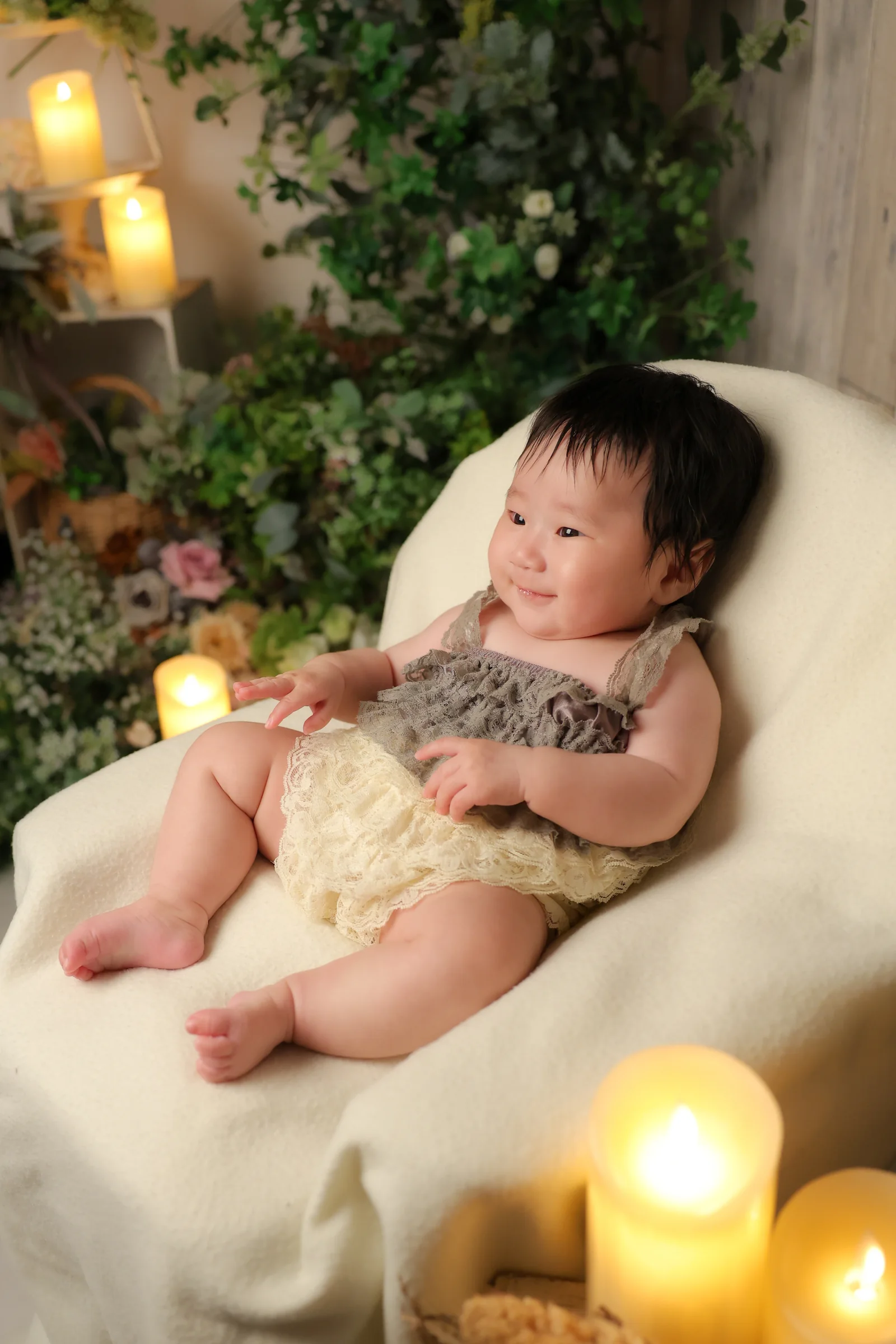 グリーンとキャンドルのセットで椅子に座る赤ちゃん
