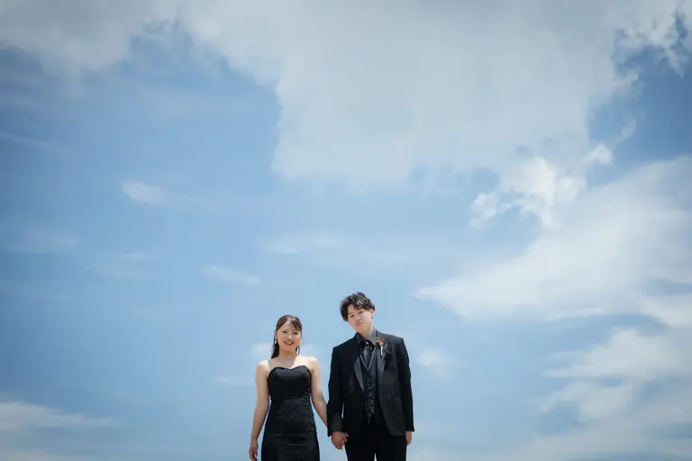 青空の下で撮る新郎新婦のウエディング写真