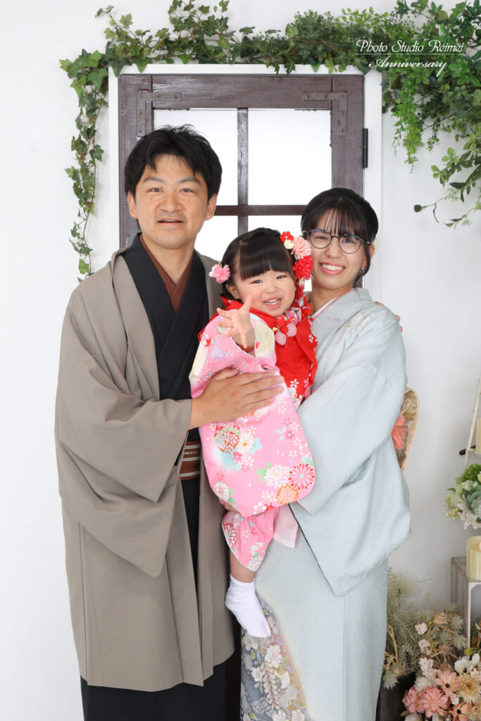 お子さまを真ん中に抱き寄せる、着物姿の家族写真