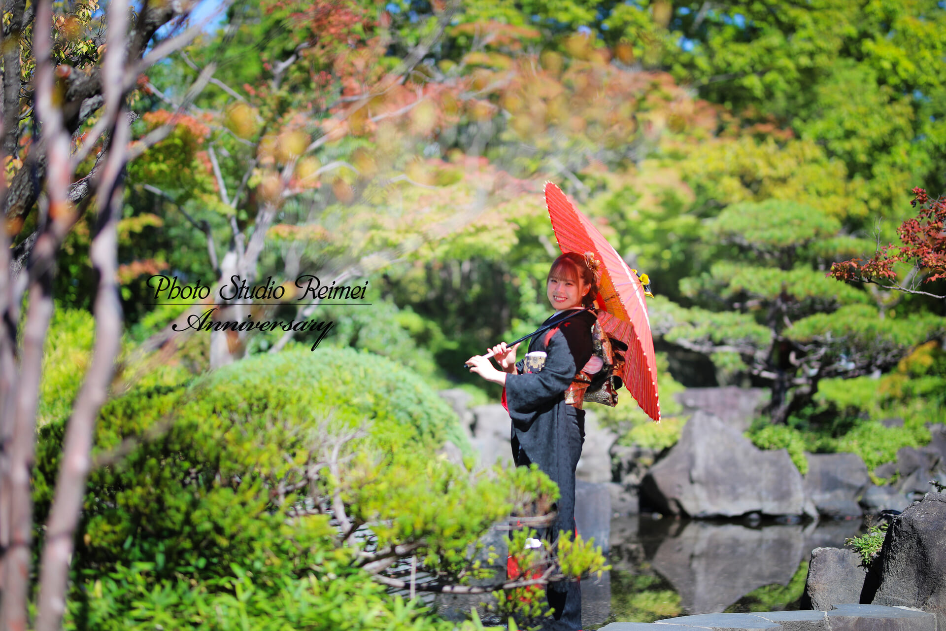 日本庭園で和傘を持って成人式前撮りをする女性
